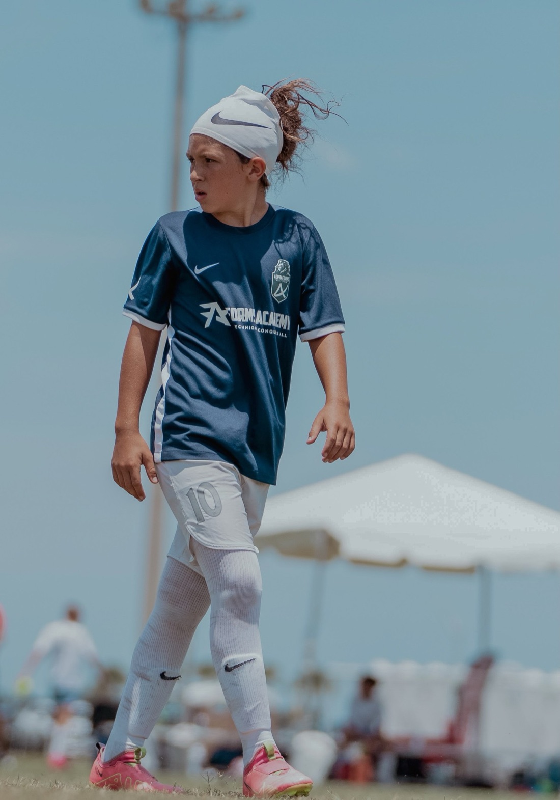 A Forms Academy player in the navy kit watching the game